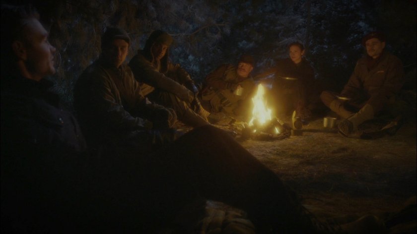 Thompson, Carter and the Howling Commandos sit around a fire in a Polish forest.