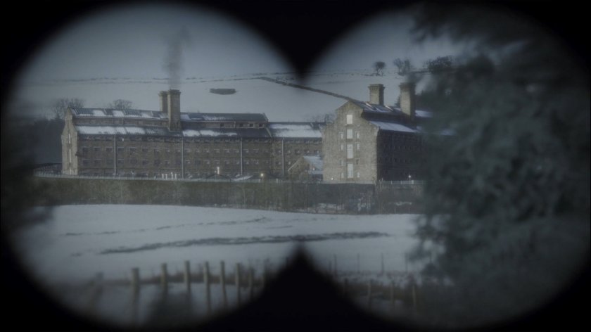 A Russian academy/prison is viewed through binoculars.