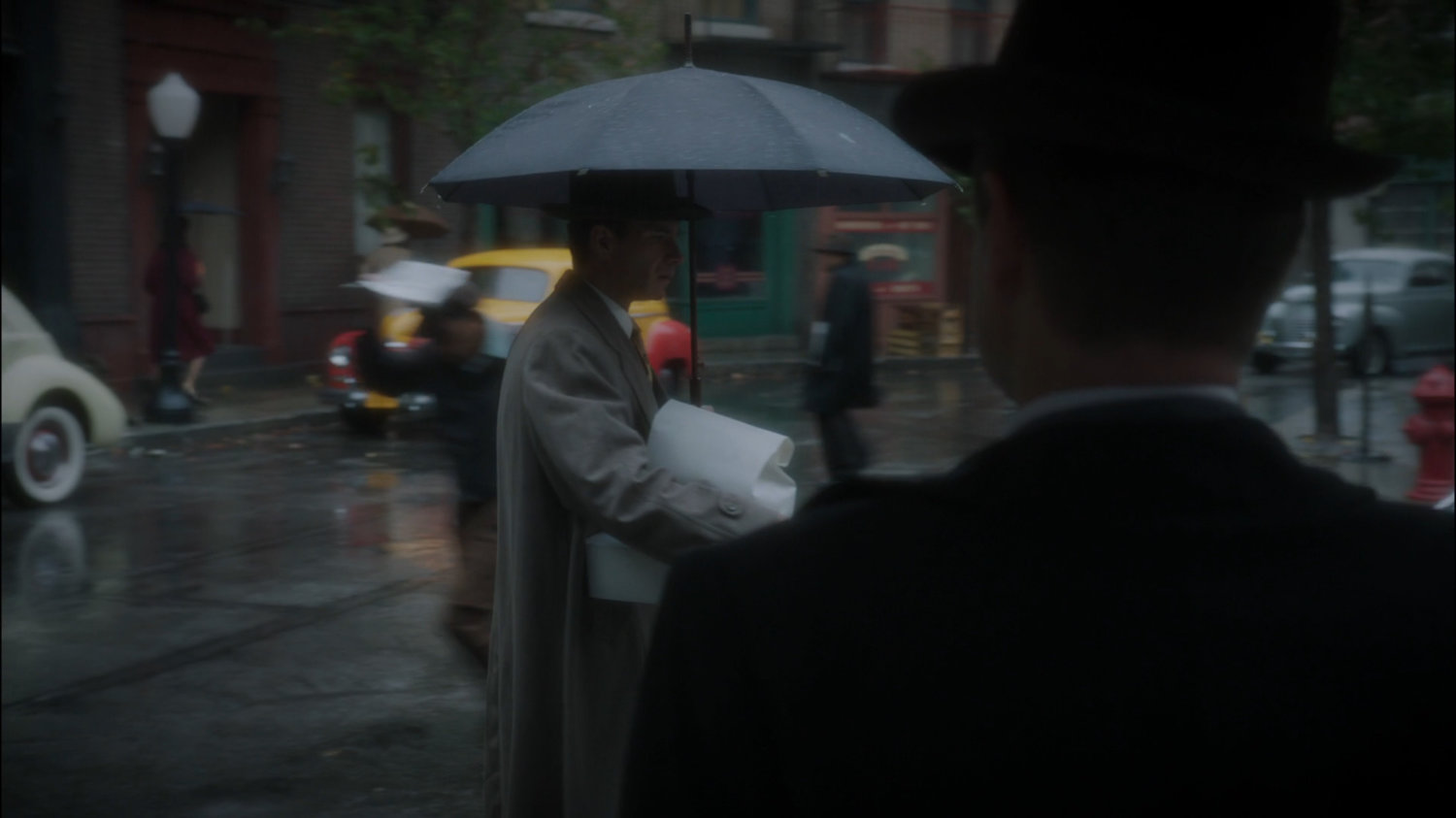 Chief Dooley speaking to Jarvis on a rainy New York sidewalk.