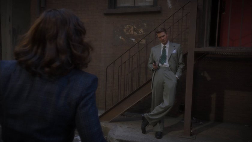Thompson confronts Peggy in alley behind Automat.