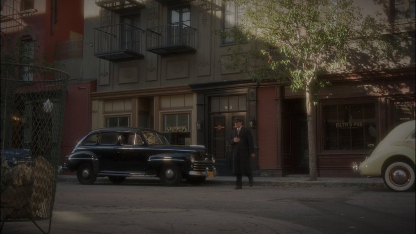 Agent Yauch crossing street outside Filth's Pub.