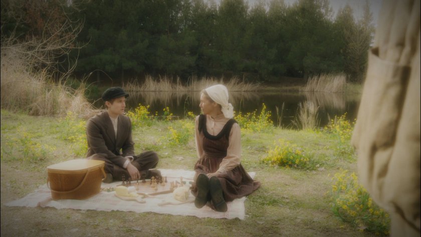 A young soldier and his mother sit by a lake.