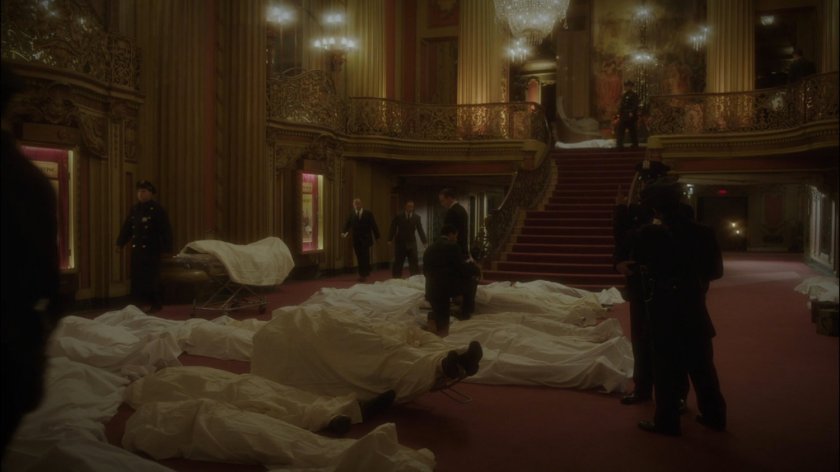 Bodies in white sheets on the floor of New York movie theater lobby.