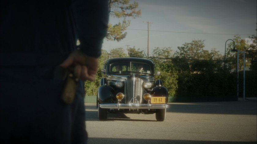Car pulls into airfield hangar.