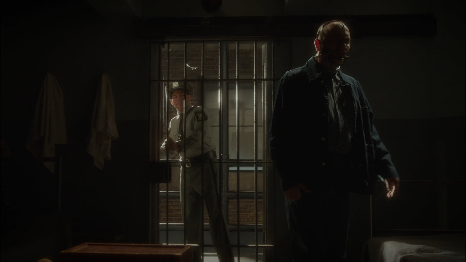 Dr. Fennhoff is locked into a cell by a guard.