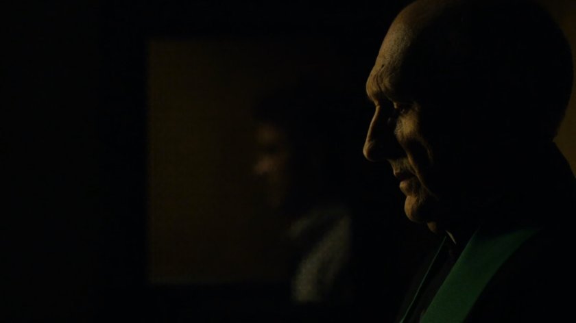 Father Lantom in a church confessional.