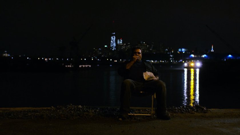Russian slaver sitting in chair at a dark container yard in Brooklyn.