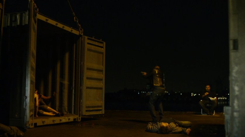 Turk draws his gun at a dark container yard in Brooklyn.