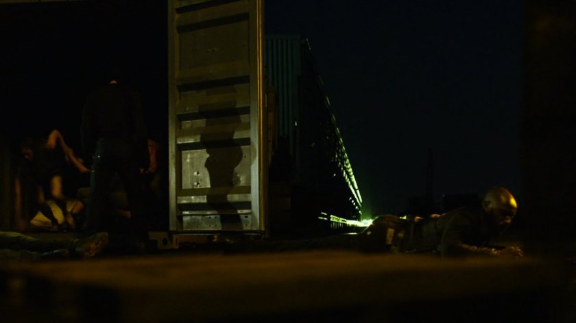 Turk crawling away at a dark container yard in Brooklyn.