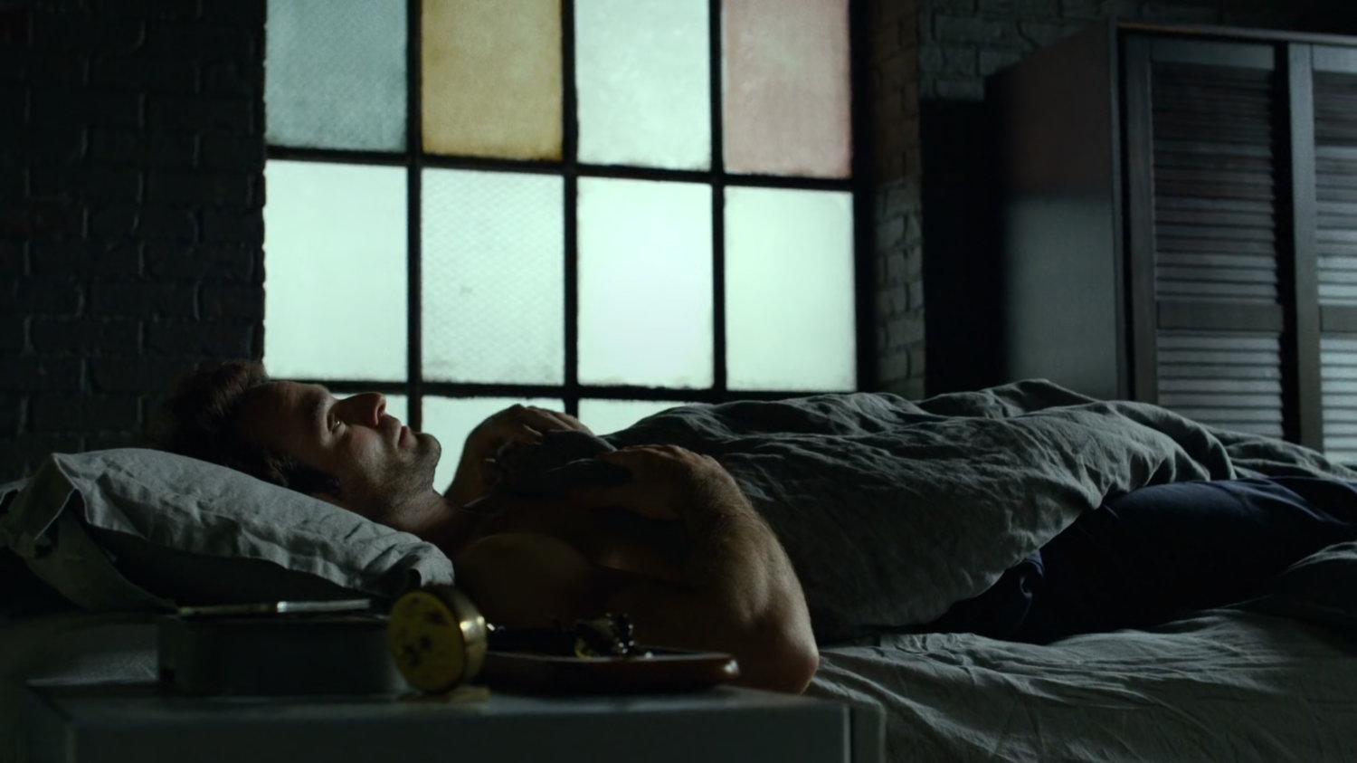 Matt in his bed at his apartment.