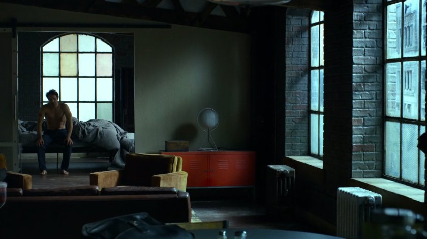 Matt sitting on his bed in his apartment.