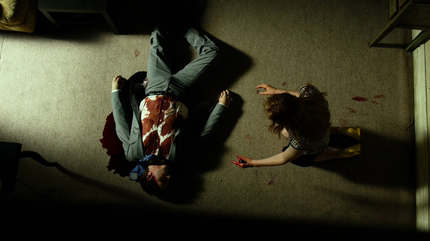 Karen Page leans over a bloody dead body in her apartment.