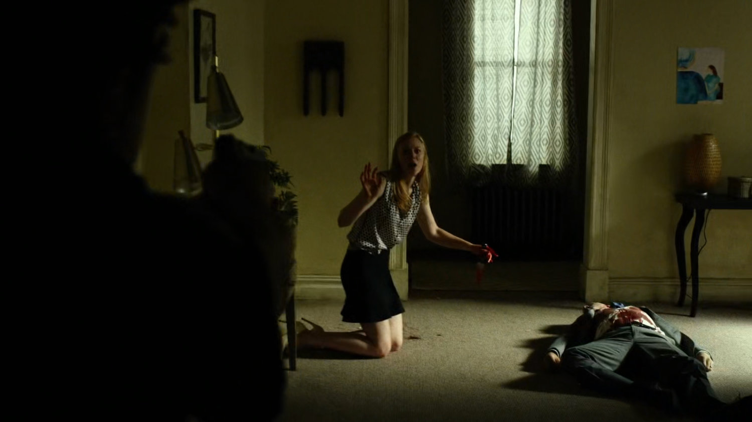 Karen Page leans over a bloody dead body in her apartment.