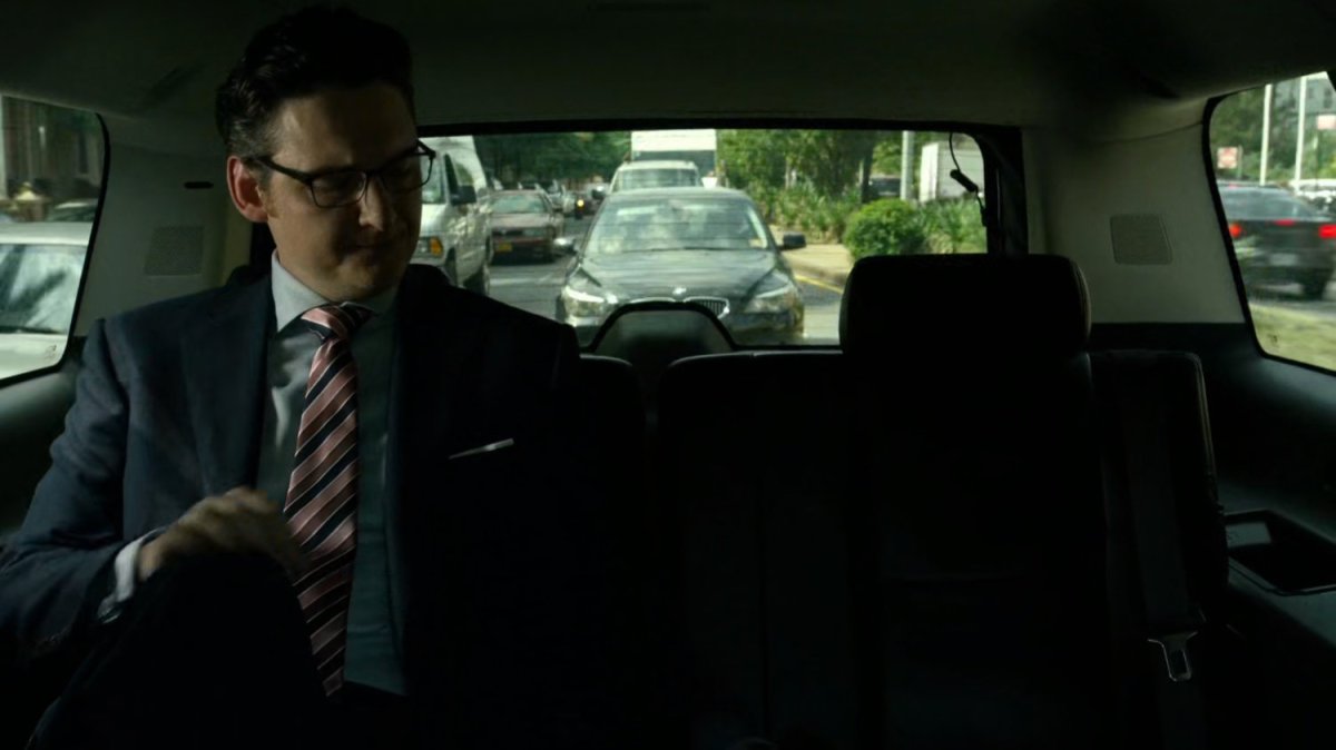 Wesley in car driving on New York street.