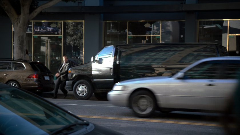 Men exit a black van on a Vancouver street.
