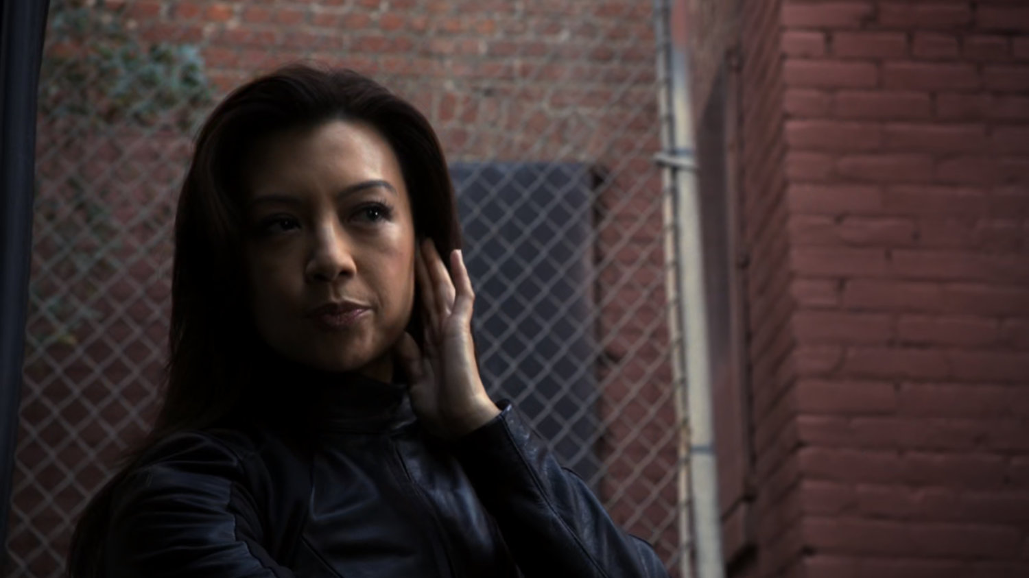 Agent May in a brick alley.