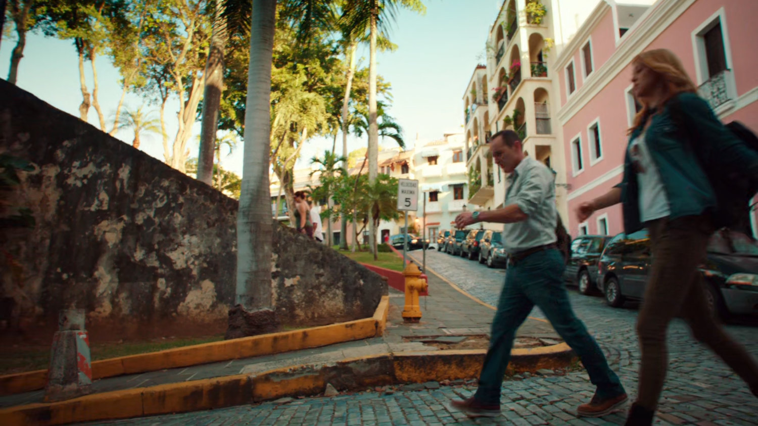 Bobbi and Coulson walk on cobblestone street in San Juan.