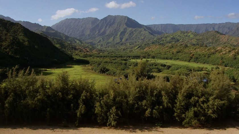 Aerial of tropical fields and mountains.