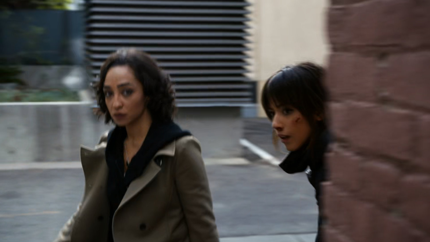 Raina and Skye enter a brick Vancouver alley.