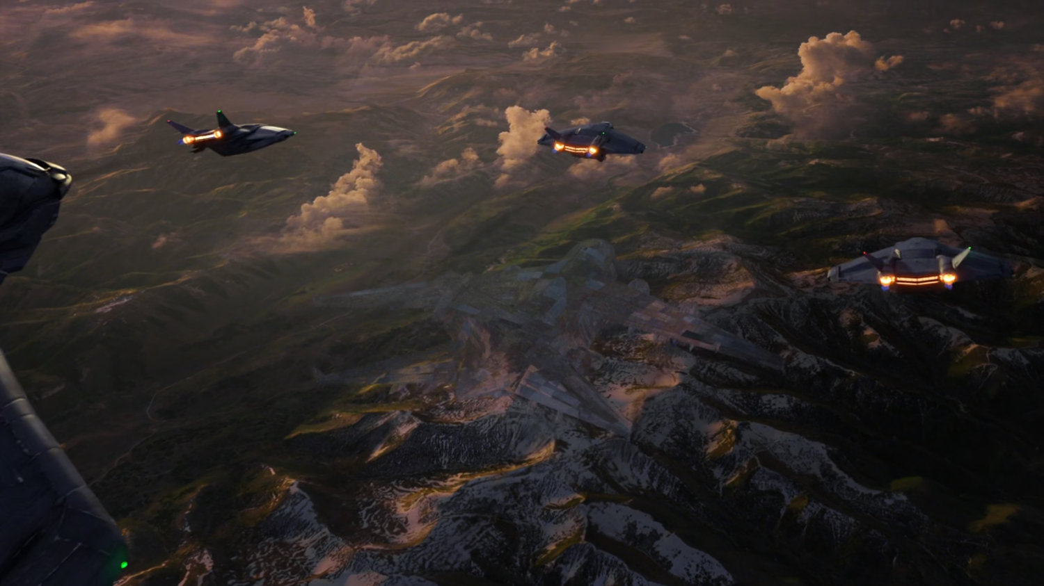 Aerial of clouds over mountains with three fighter planes in the air.