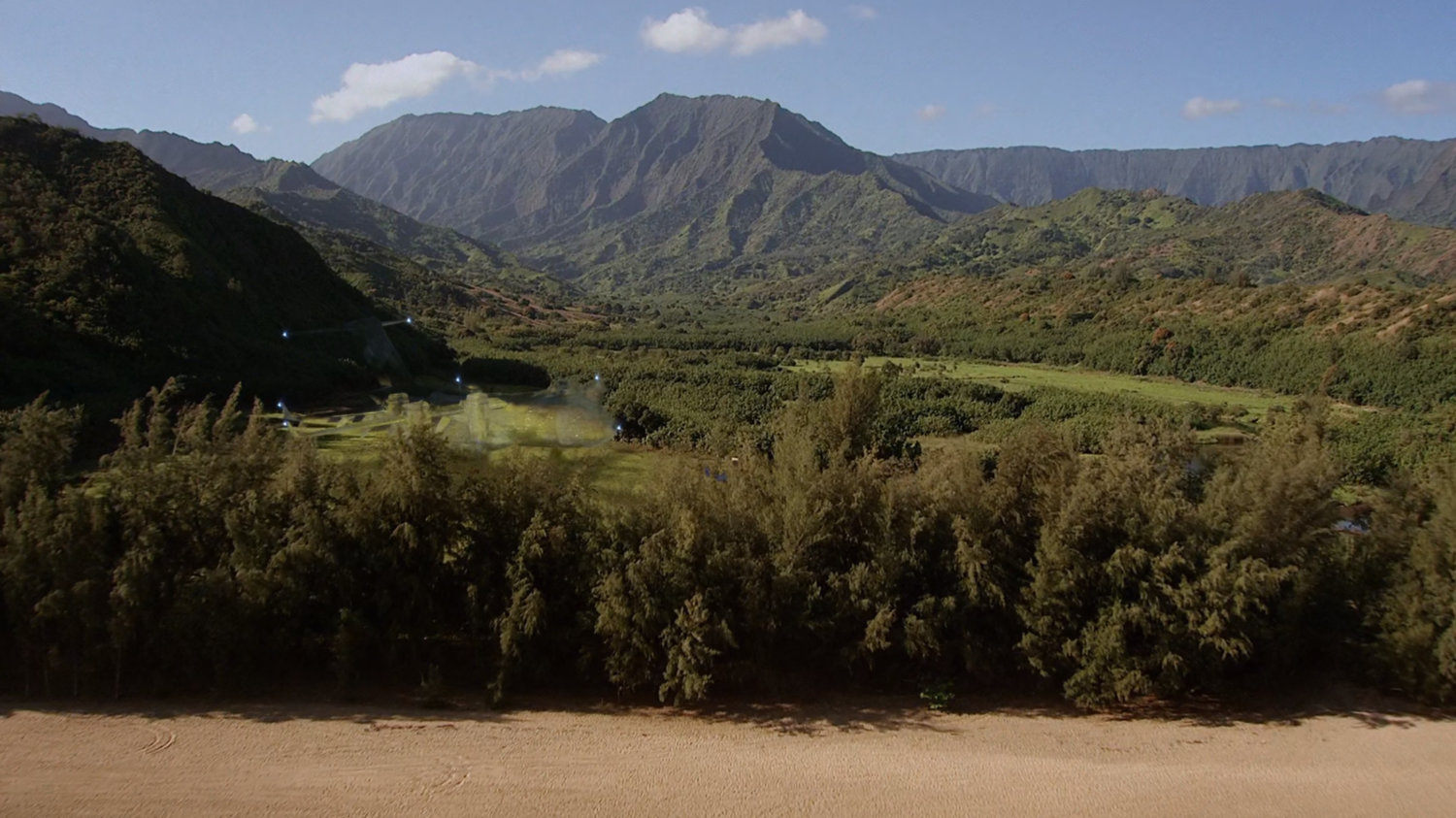Aerial of tropical fields and mountains.