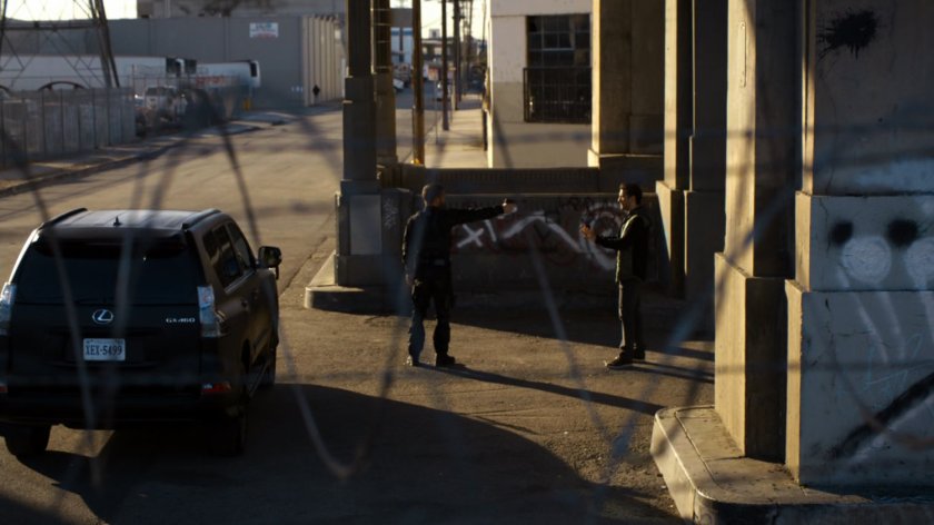 Hunter draws a gun on Bakshi underneath a bridge.
