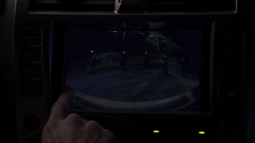 Closeup of backup camera in SUV with gunmen outside.