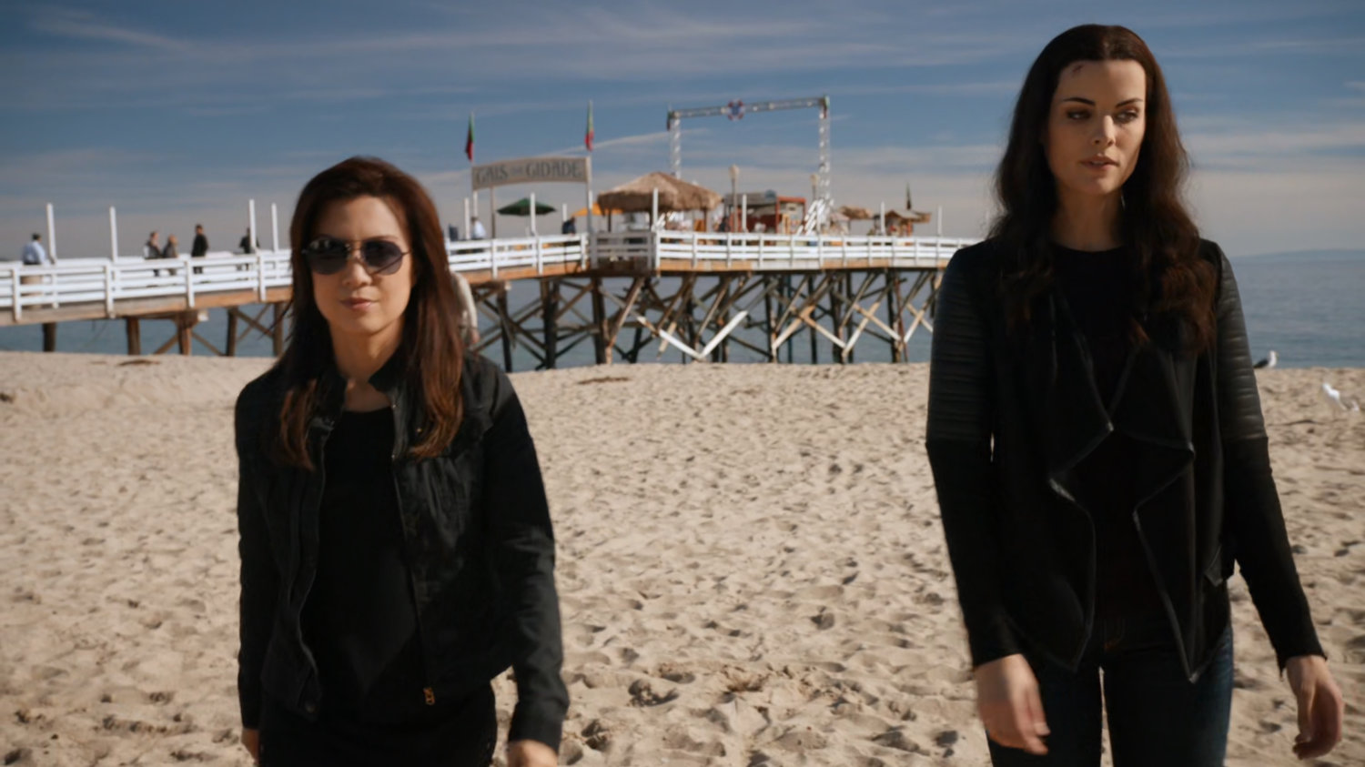 May and Sif on Faro beach with pier in background.