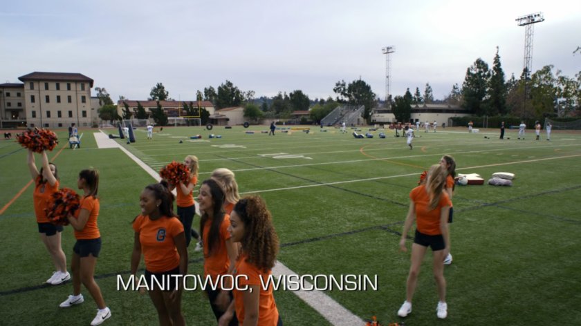Cheerleaders on football field. Text: Manitowoc, Wisconsin.