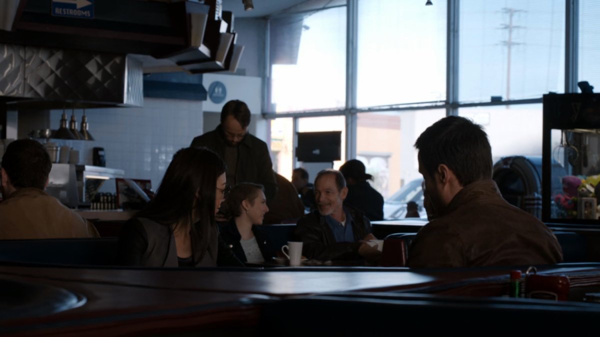 Agent 33 and Ward looking at customers in a diner.