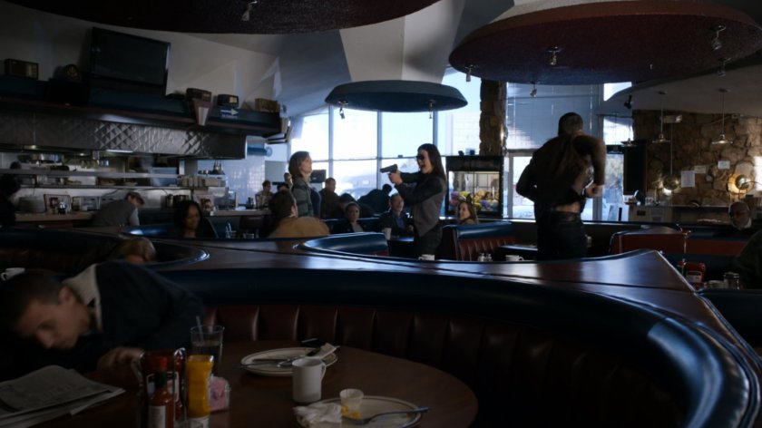 Agent 33 and Ward draw guns on customers in a diner.