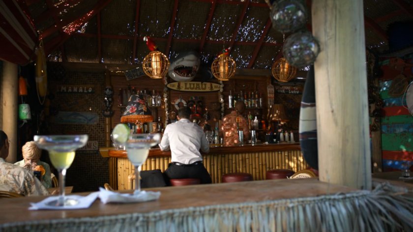 Coulson sitting in tiki bar.