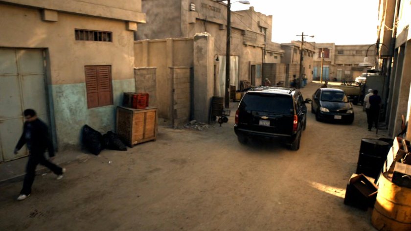 Black SUV drives down dirt street in Bahrain.