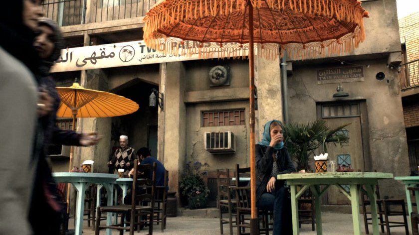 Woman sitting at table outside Two Palms Cafe in Bahrain.