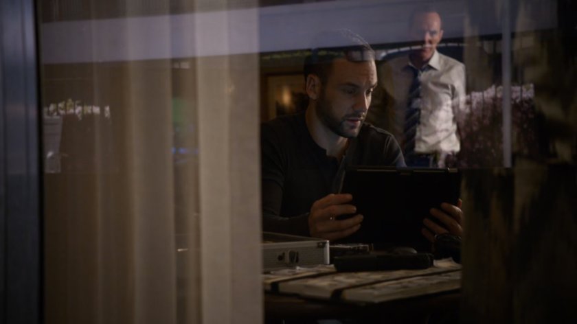 Looking at Coulson and Hunter inside motel room from outside.