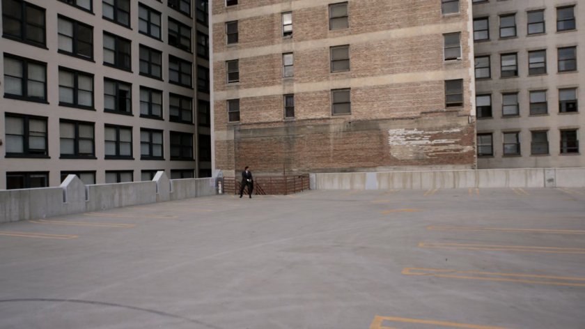Man on empty parking garage roof deck.
