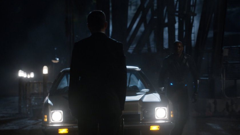 Coulson in oil field at night in front of car.