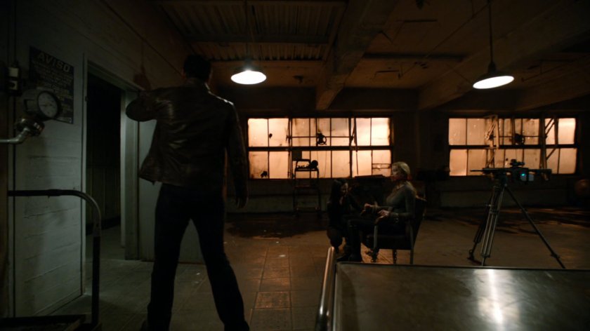 Ward ties Bobbi to chair as bait in a trap inside an abandoned Spanish warehouse.