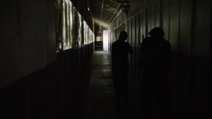 SHIELD Agents in a hallway of an abandoned Spanish warehouse.