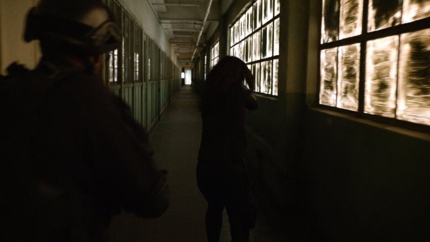 SHIELD Agents in a hallway of an abandoned Spanish warehouse.