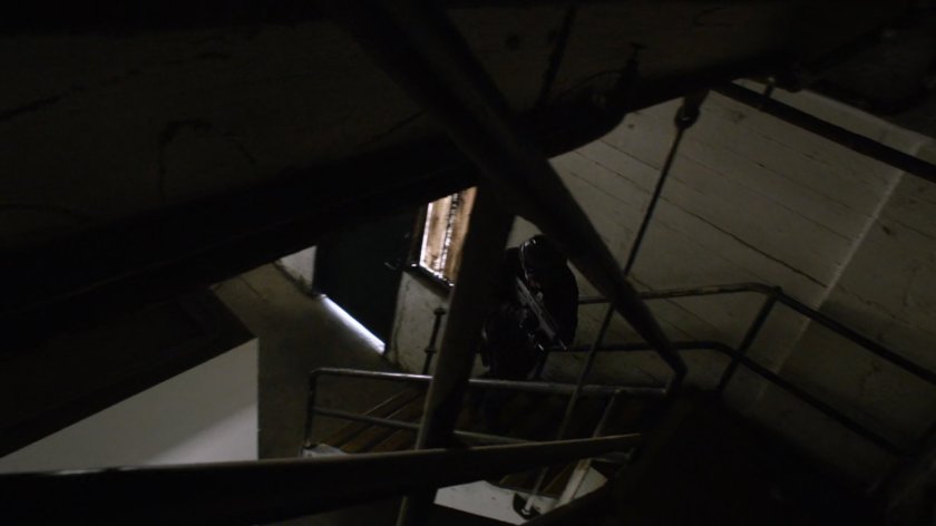 SHIELD Agent in a stairway of an abandoned Spanish warehouse.