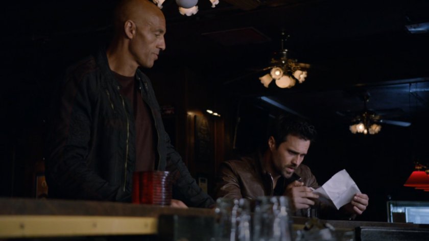 A bald man approaches Ward in a bar.