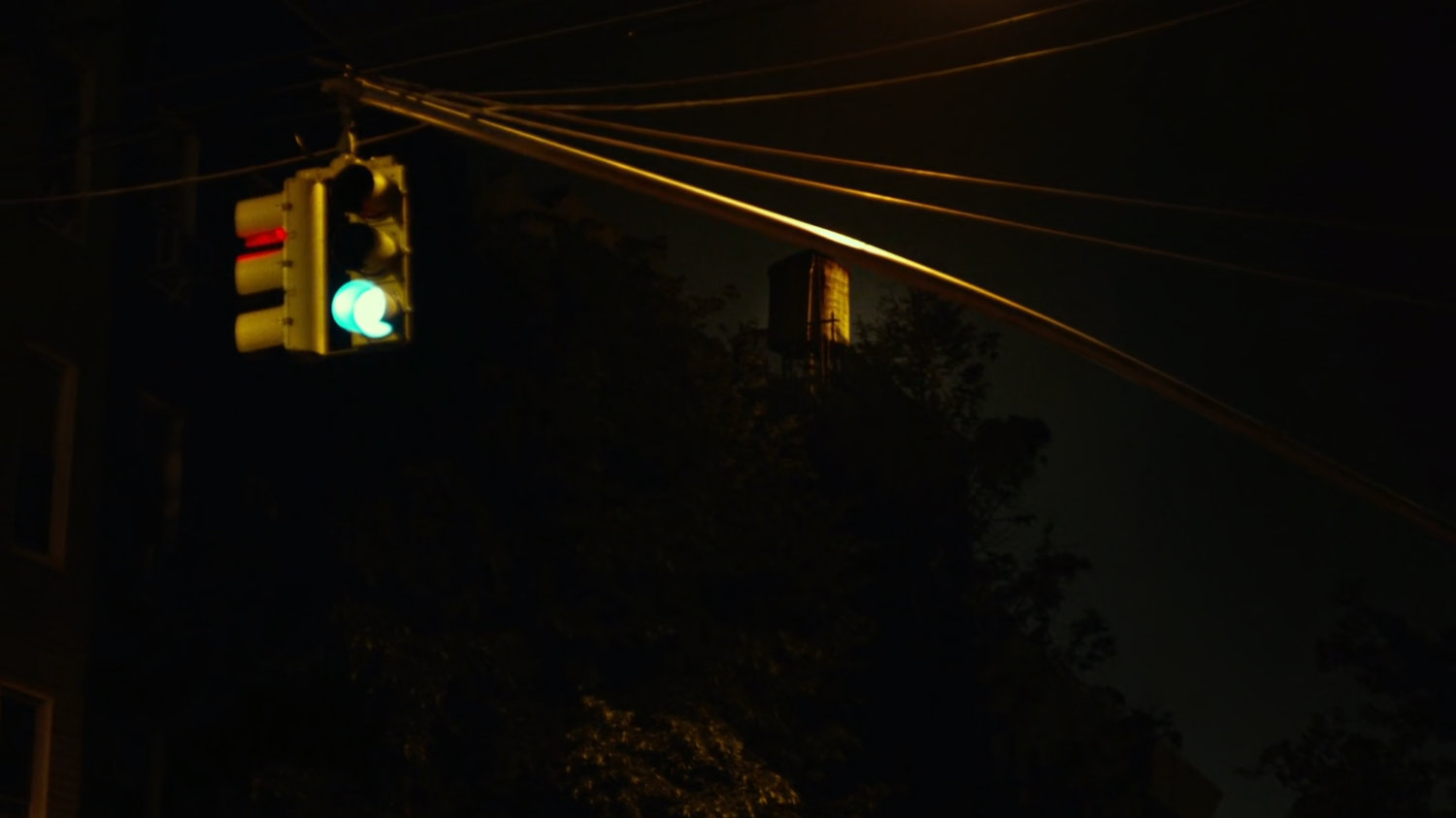 Watertower as seen from intersection at night.