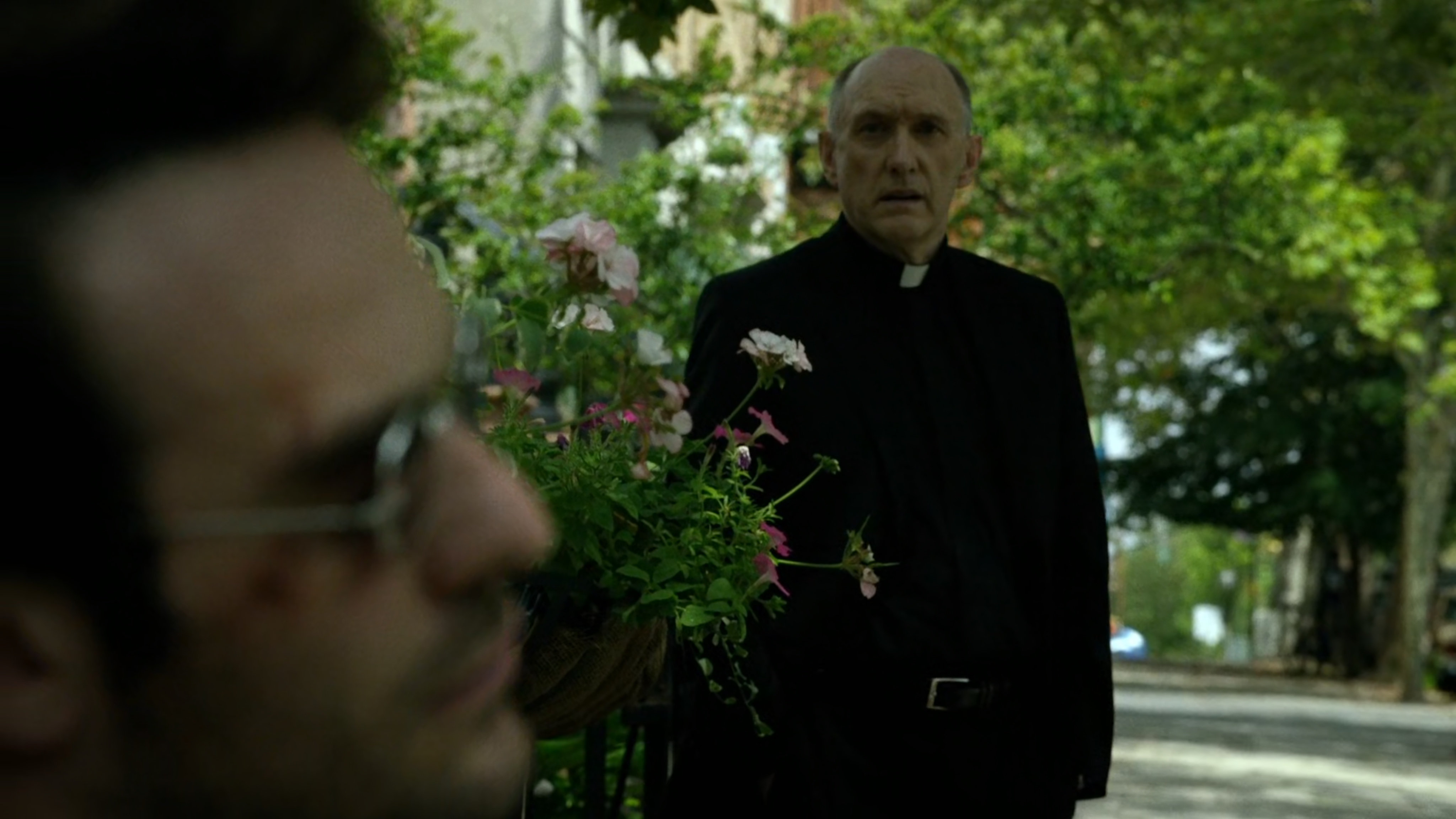 Father Lantom approaches Matt outside church.
