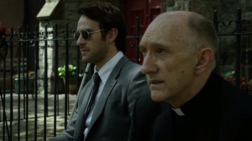 Father Lantom and Matt sit outside church.