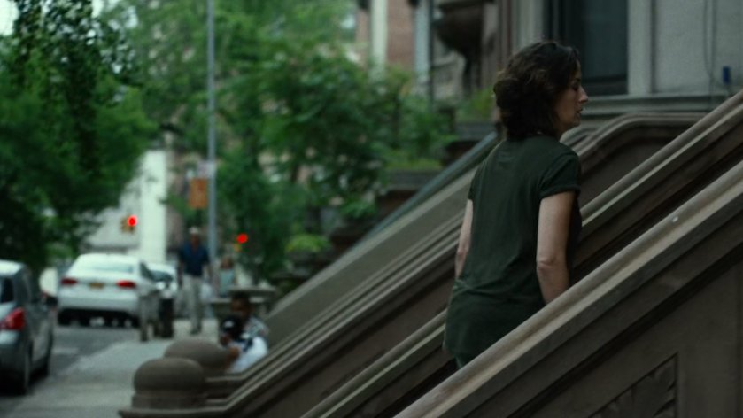 Mrs Fisher on steps of brownstone.