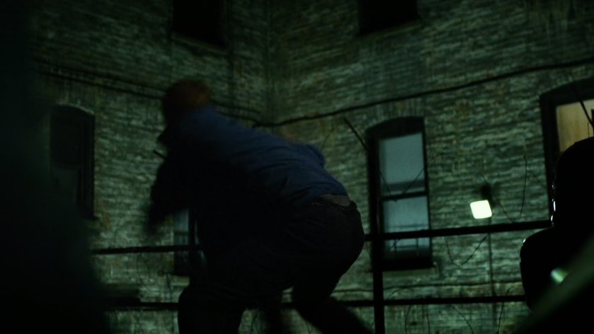 Daredevil fights Healy in dark alley.