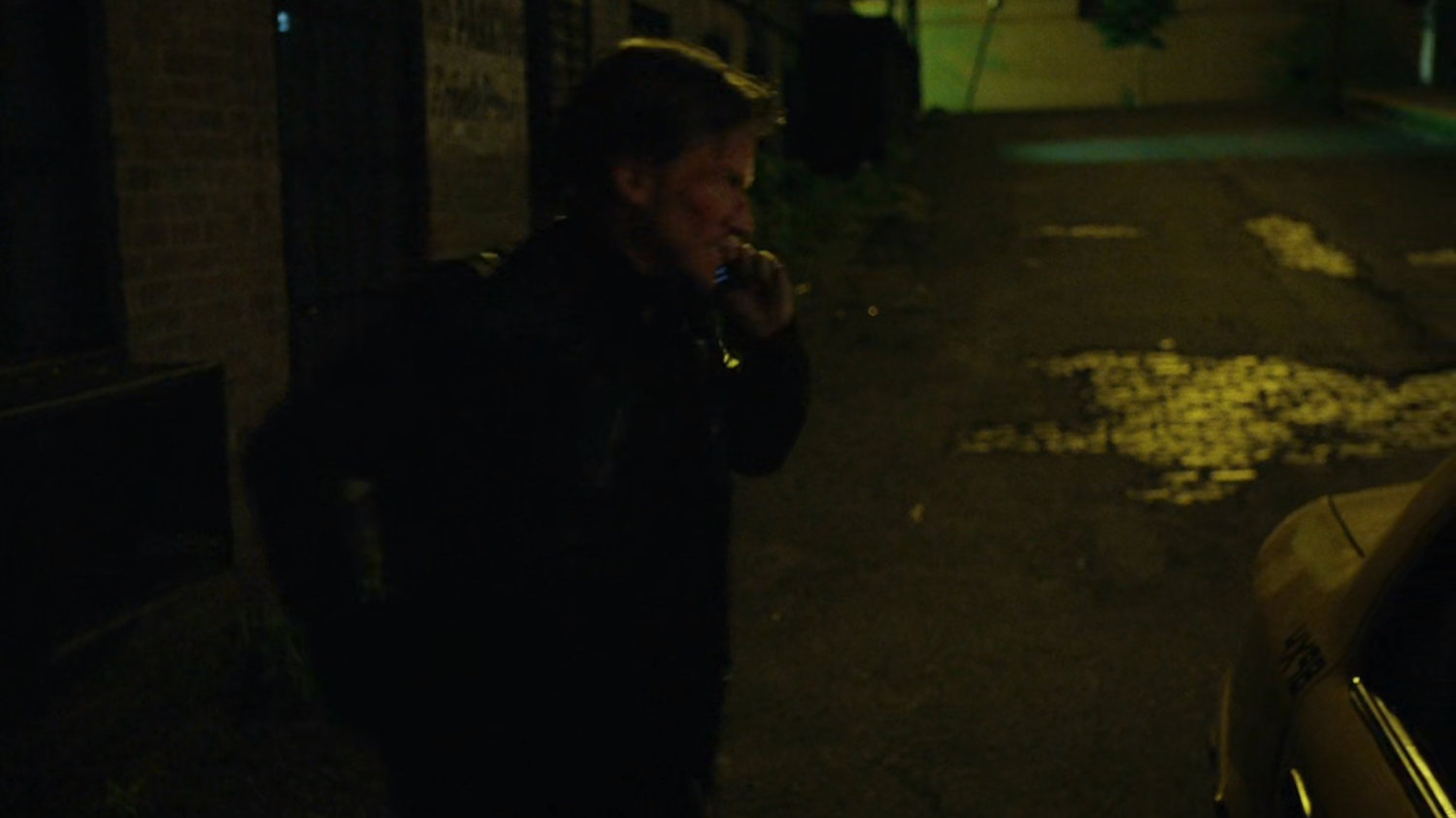 Anatoly on phone in alley.