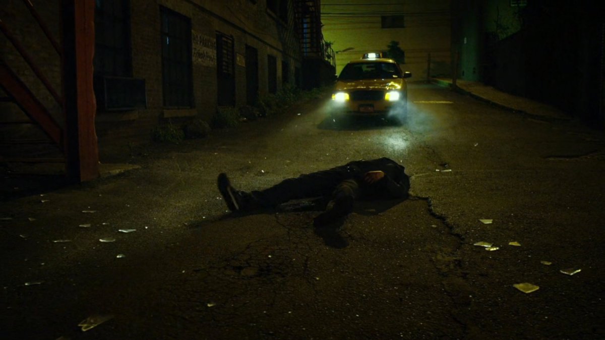 Cab driving away from body laying in alley.