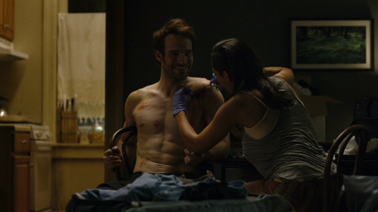Claire stitching up Matt in her coworker's apartment.